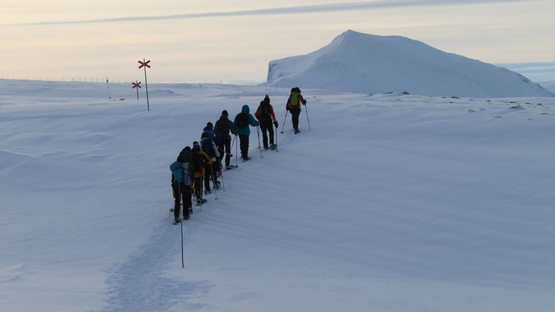 © Emmanuelle Dechamps Groupe en raquettes sur un plateau enneigé en direction d'un sommet - Norvège