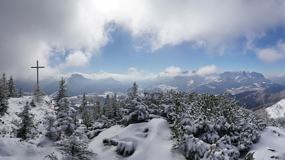 Croix de sommet enneigée et panorama alpin - Alpes