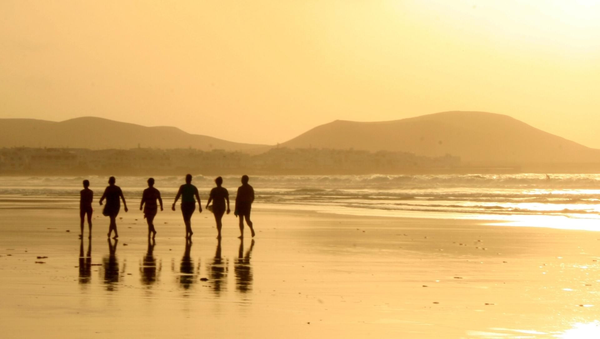 Promeneurs sur une plage au coucher du soleil à Lanzarote - Canaries - Espagne