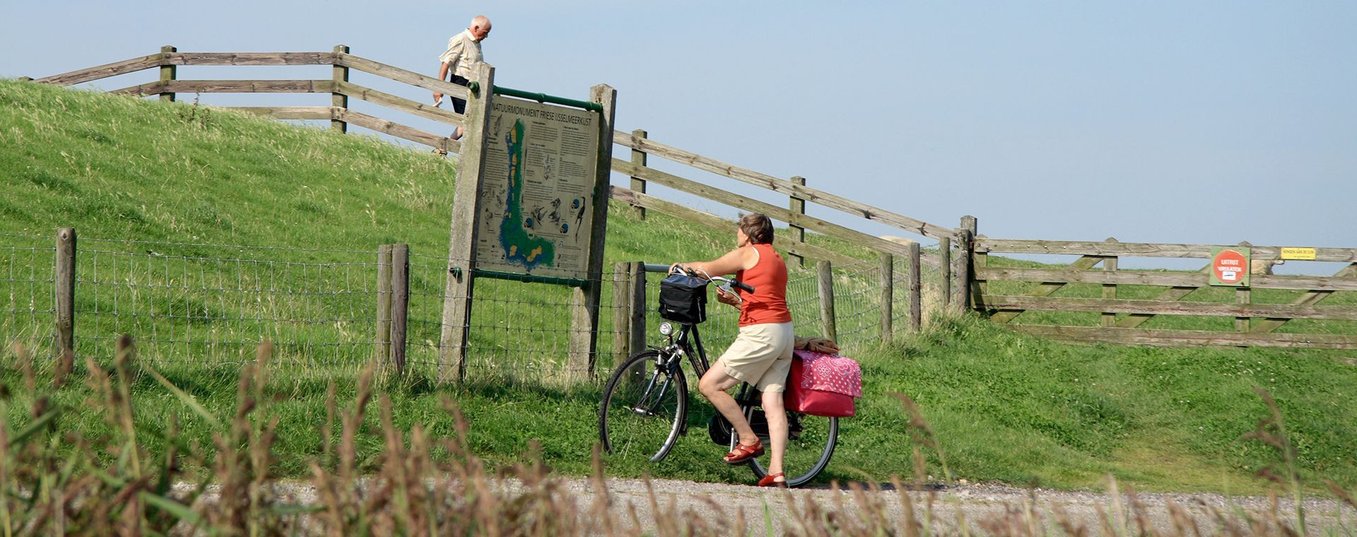 Cycliste sur une digue le long des polders - Frise - Pays-Bas