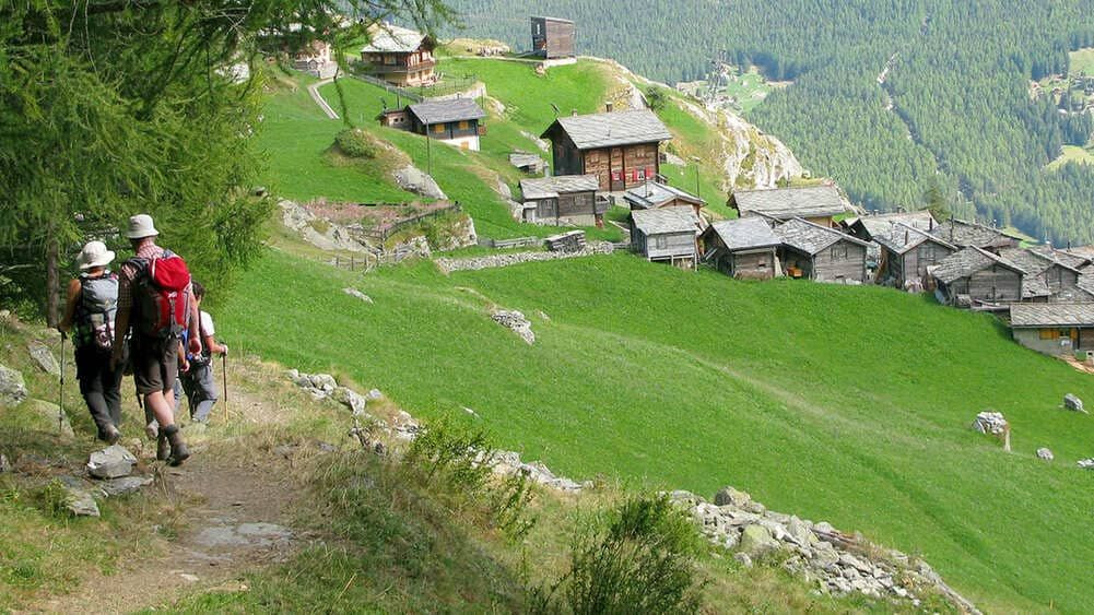 Randonneurs sur sentier vers hameau d'alpage - Val d'Hérens - Suisse