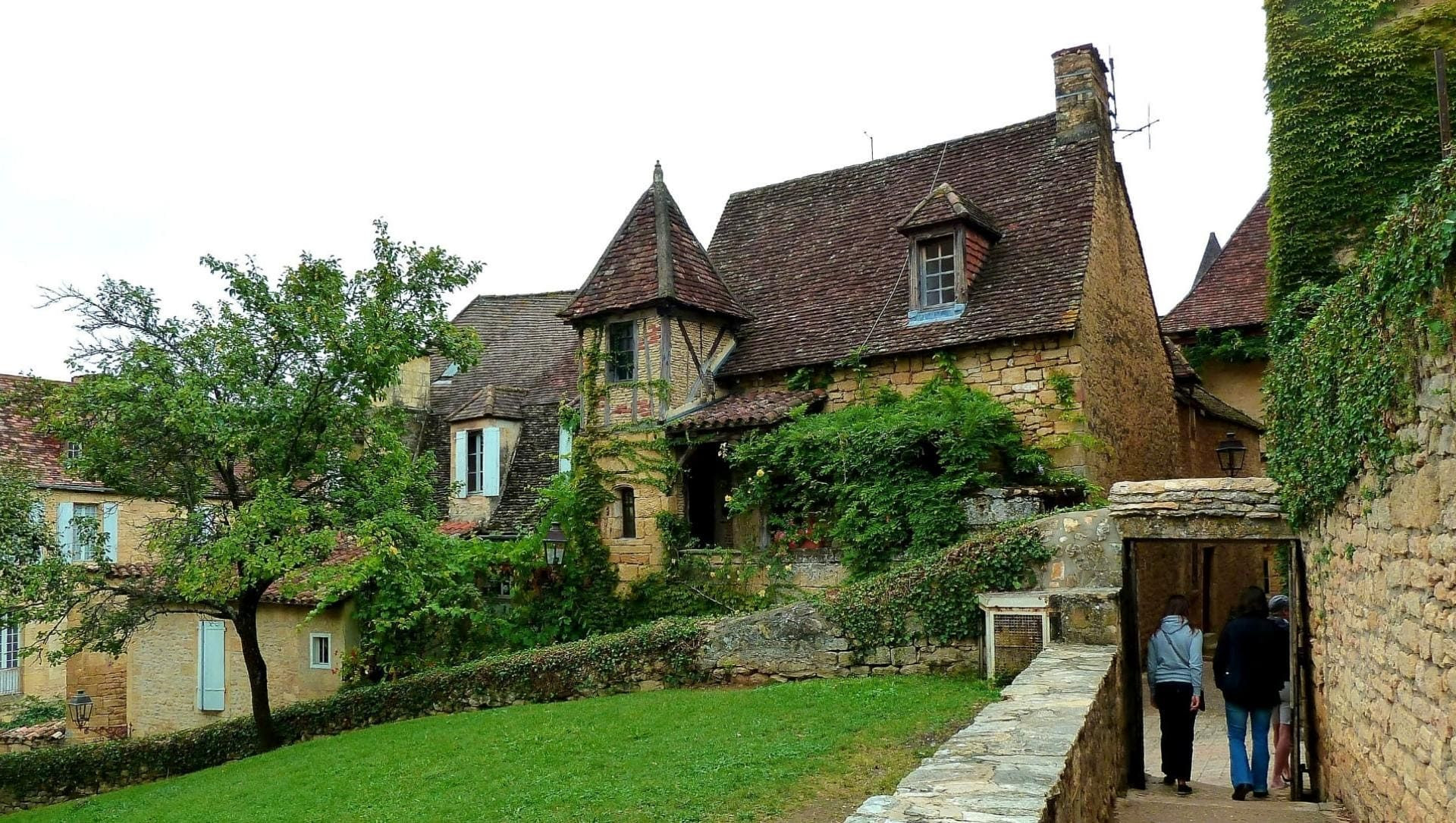 Randonneurs dans un village médiéval en pierre - Périgord - France